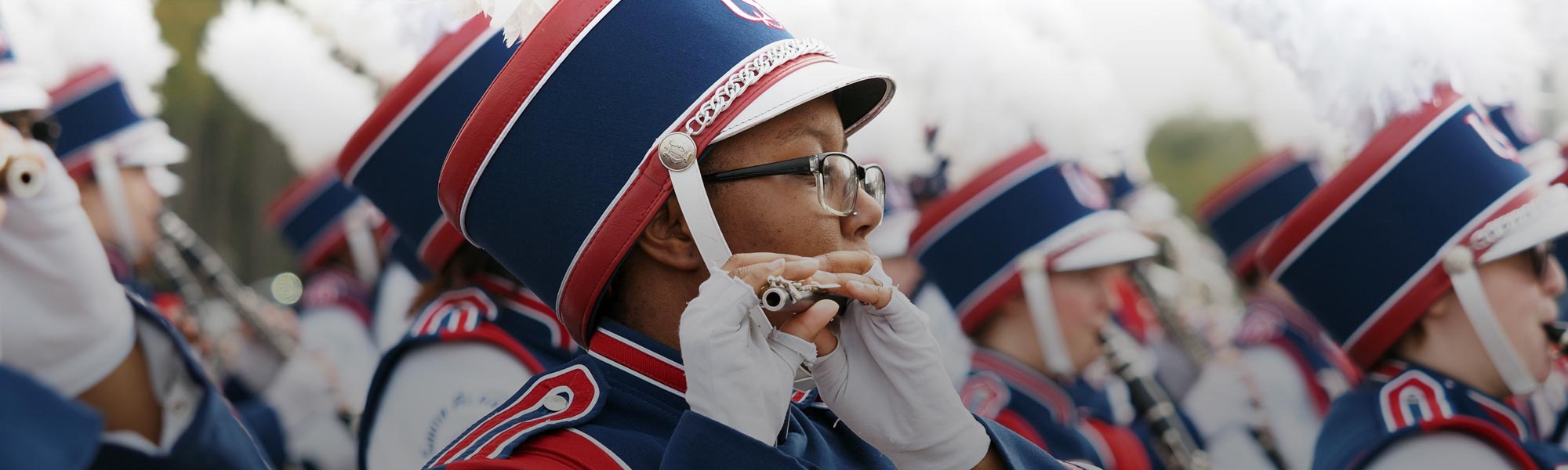 female band member marching while playing the flute