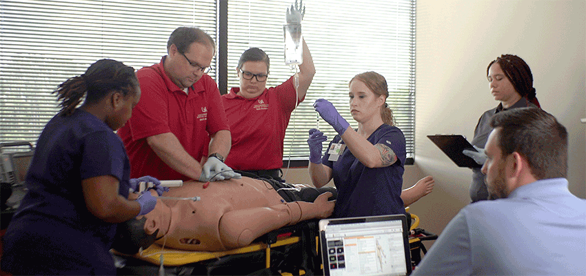 Image of EMS students with simulation body.