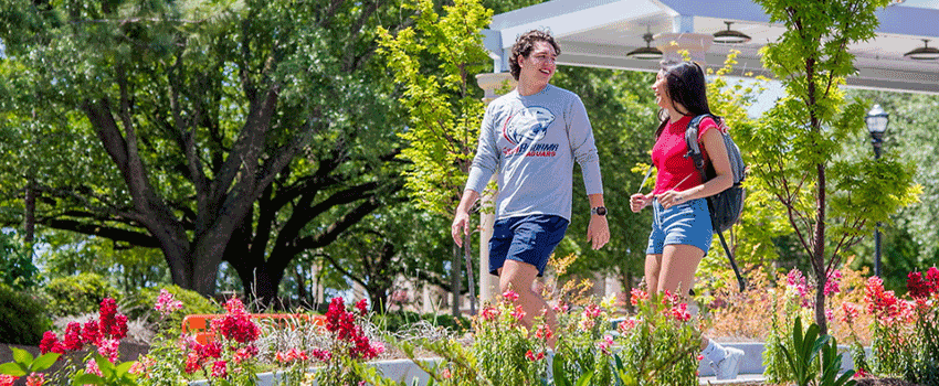 Two students walking outside across campus.