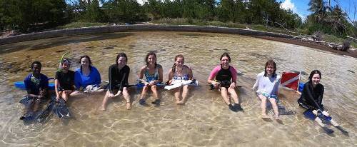 marine science undergraduates sitting in water