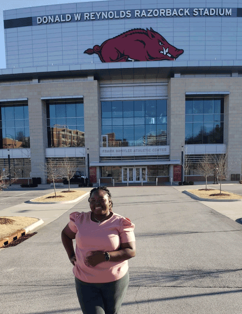 Margie Pemu in front of University of Arkansas stadium.