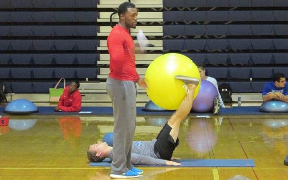 Male student coaching an exercise class.