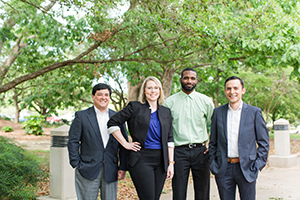 Graduate students standing out side of Mitchell College of Business.