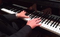 Pictured are a pianist's hands on the keyboard.