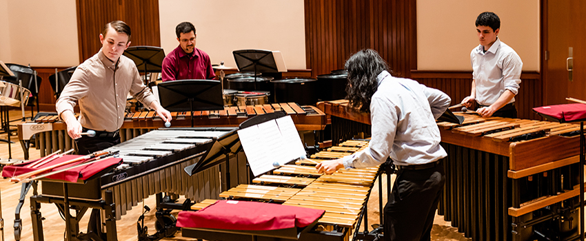 Students in the percussion ensemble playing their instruments.