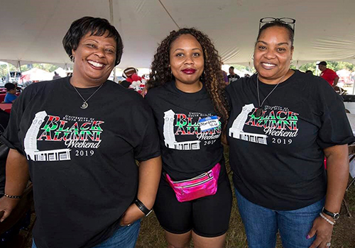 Three members of the Black Alumni Society under the tent at the Black Alumni Weekend.