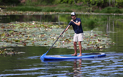 Student kayaking in water on campus.