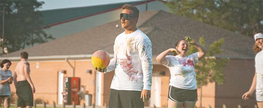 Students playing dodgeball on campus at a tournament.