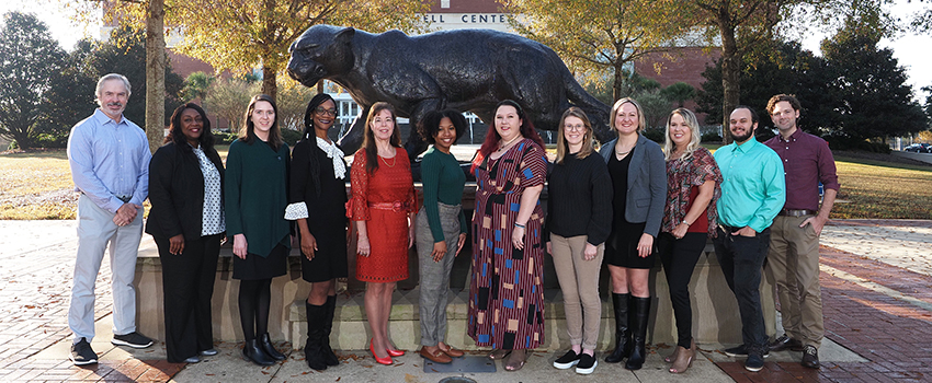 Group picture of Counseling and Testing staff outside in front of jaguar statue.