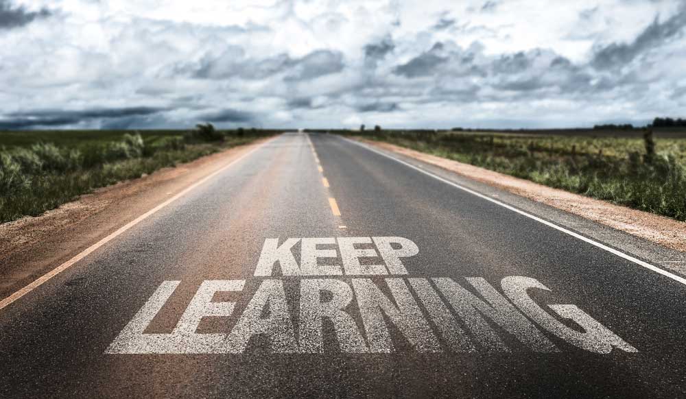 Picture of open road with the phrase keep learning 