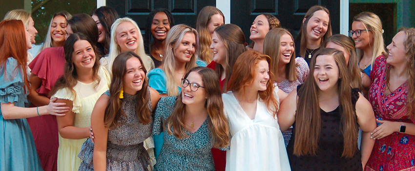 Sorority members smiling and laughing in a group.