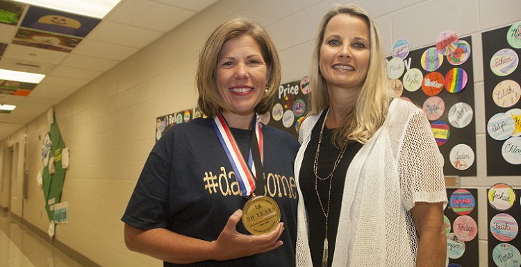 Newly-named Alabama Teacher of the Year Chasity Collier, left, receives a special 50th Anniversary medallion from Dr. Andrea Kent, dean of the University of South Alabama College of Education, during a surprise celebration pep rally at Dawes Intermediate School. Earlier this year, South Alabama’s College of Education celebrated 50 years. Collier teaches fifth-grade science at Dawes Intermediate School. data-lightbox='featured'