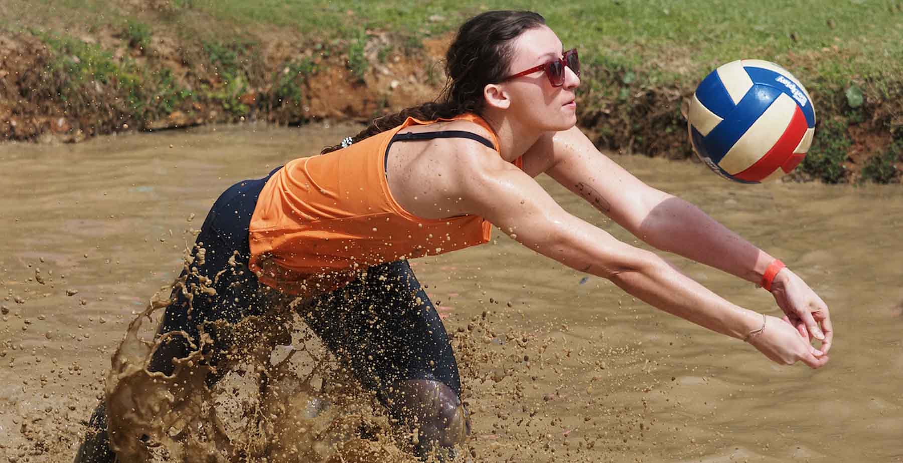A University of South Alabama student serving a volleyball during Oozeball, the annual mud volleyball tournament. 
