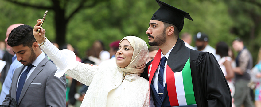 A graduate taking a selfie with a guest