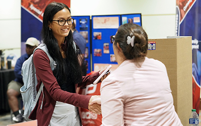 Student shaking hands with someone at Get on Board Day.