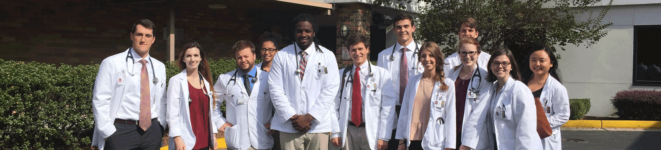 Medical students standing in front of the College of Medicine