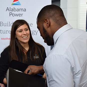 Alabama Power set up at spring career fair with employee talking to student